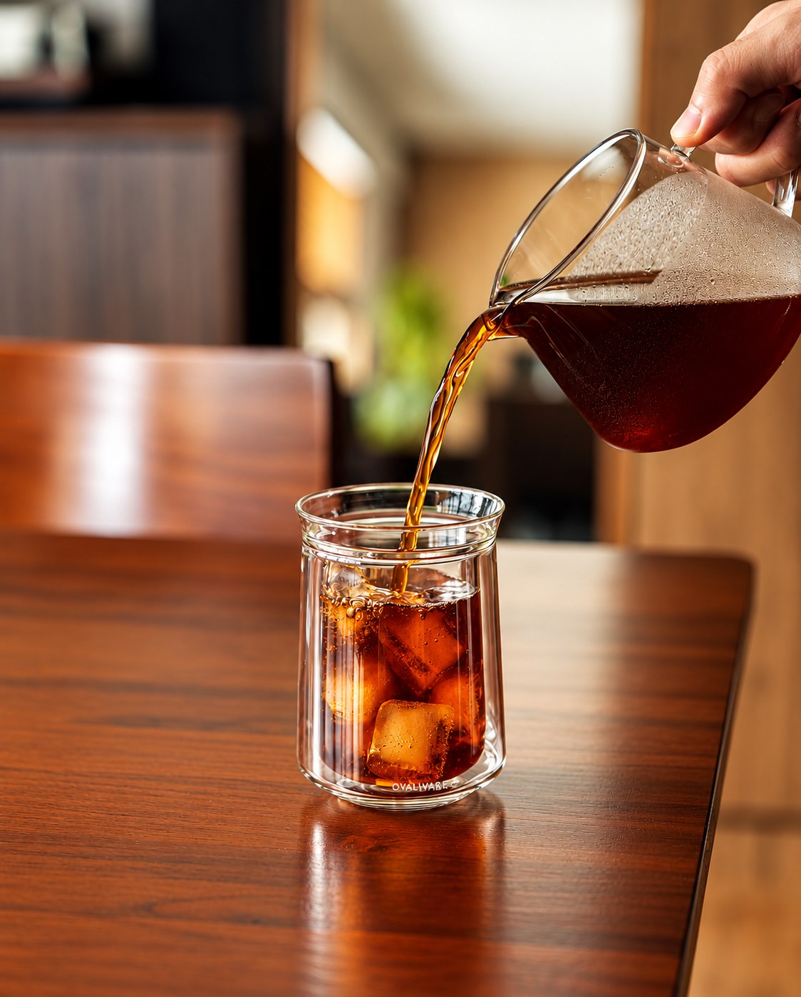 Freshly brewed coffee poured from a glass carafe over ice